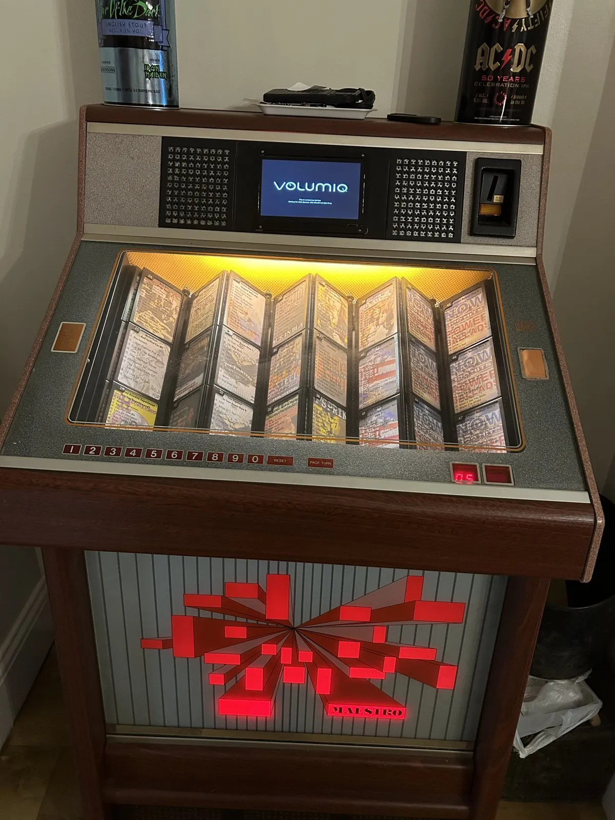 Jukebox per CD con finiture in legno e un piccolo schermo Volumio sopra le schede degli album illuminate
