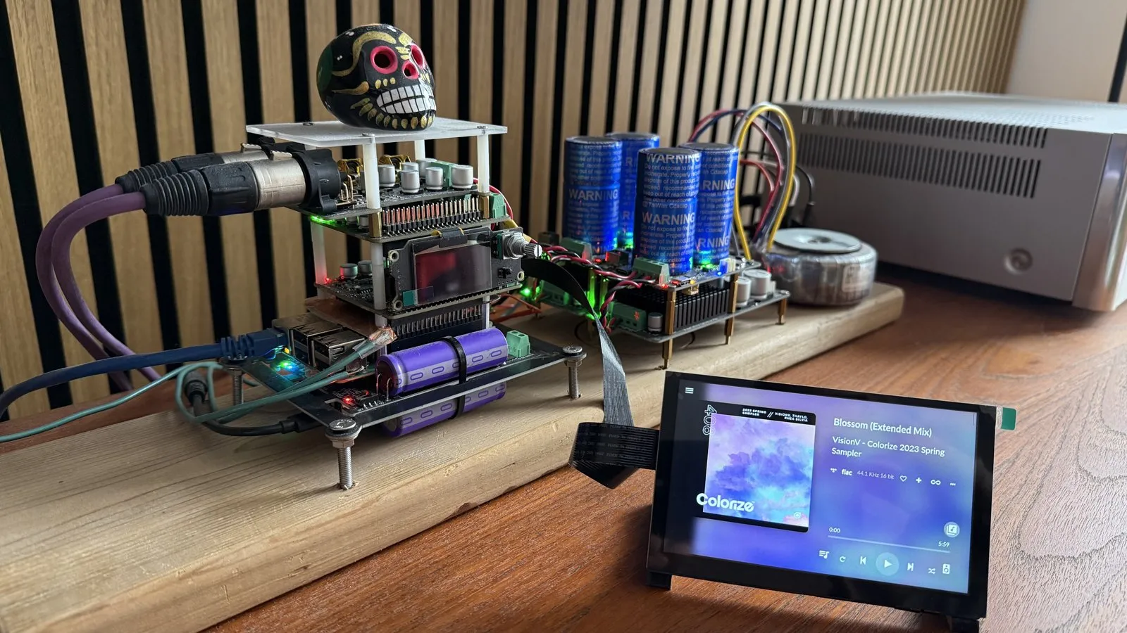 Torre aperta di schede elettroniche su un'asse di legno, accanto a un touchscreen