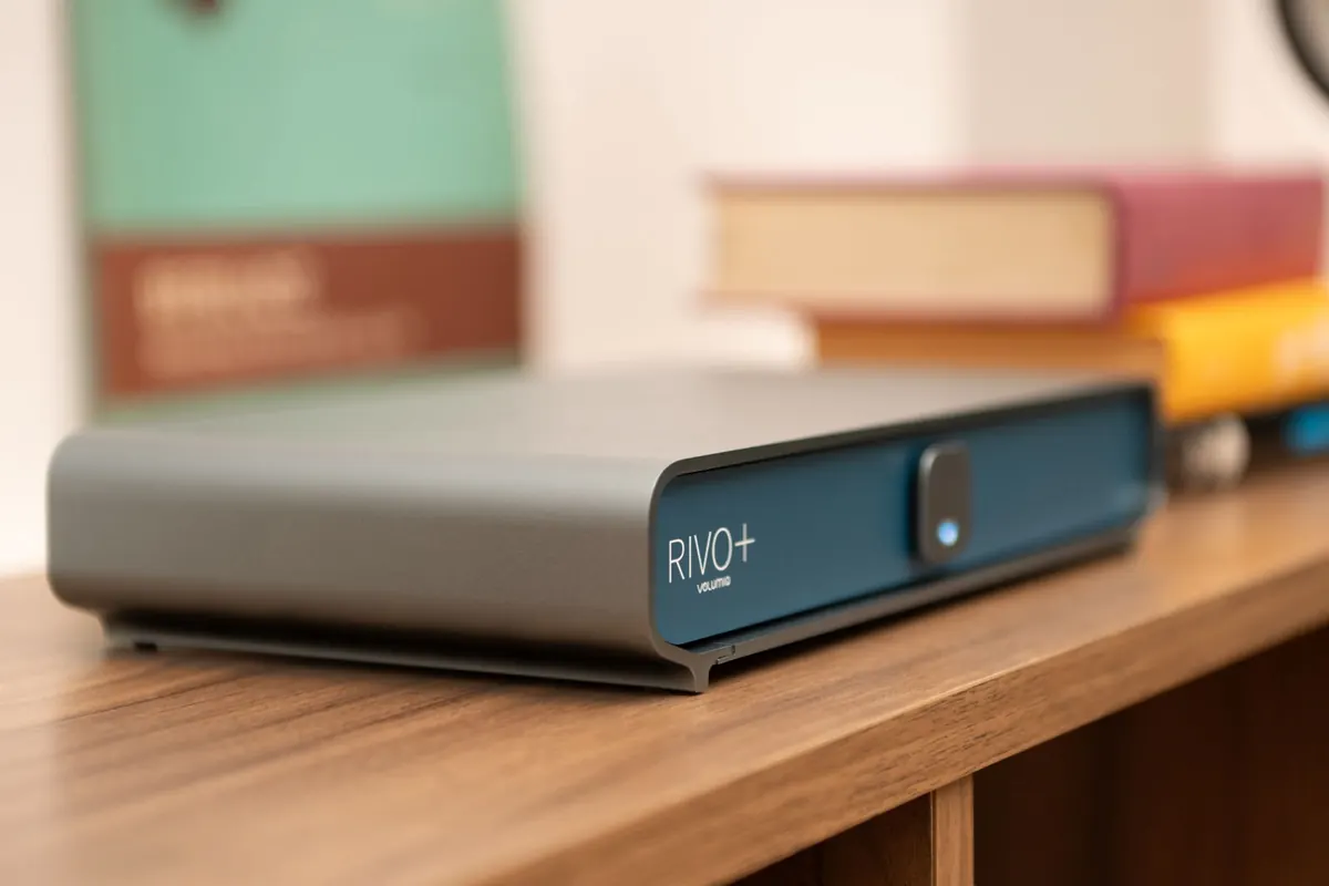 Rivo Plus in the Classic finish on a wooden shelf, in front of a stack of books.