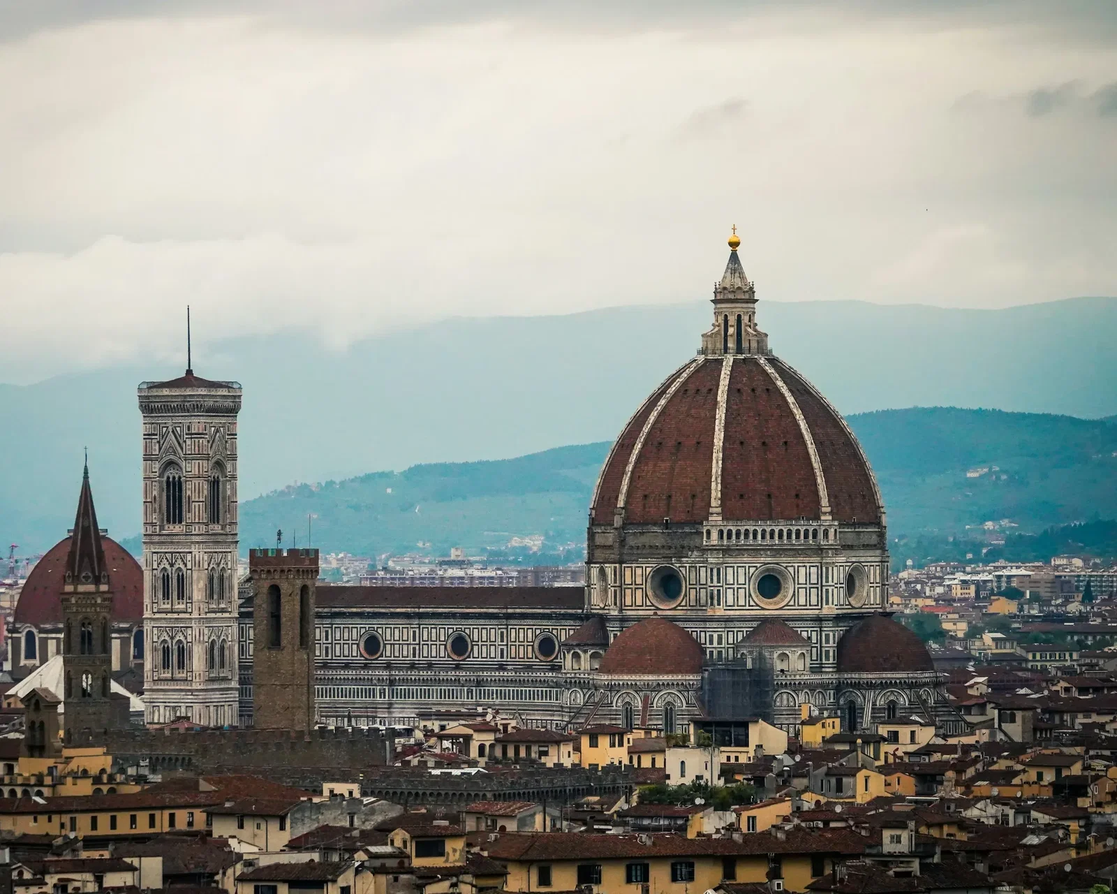 Florence seen from across the Arno, with the Duomo and Giotto's bell tower above the rooftops.